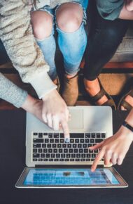 three person pointing the silver laptop computer