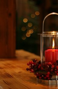 red lighted candle on brown wooden frame